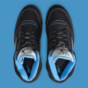 Air Jordan 5 Retro Black University Blue 2026 en nubuck noir avec accents bleus, languette réfléchissante et unité Air visible au talon.