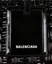 Balenciaga Bistro S Basket Top Handle Bag Black en matière tressée noire avec deux anses roulées, étiquette siglée et bandoulière amovible.