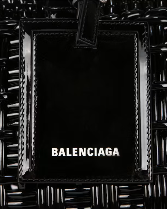 Balenciaga Bistro S Basket Top Handle Bag Black en matière tressée noire avec deux anses roulées, étiquette siglée et bandoulière amovible.
