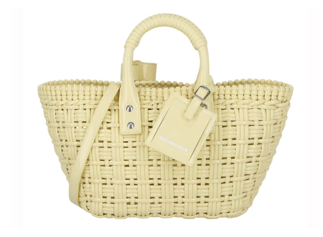 Balenciaga Bistro Strap Basket XS Yellow en matière tressée jaune avec deux anses roulées, étiquette Balenciaga et bandoulière amovible.