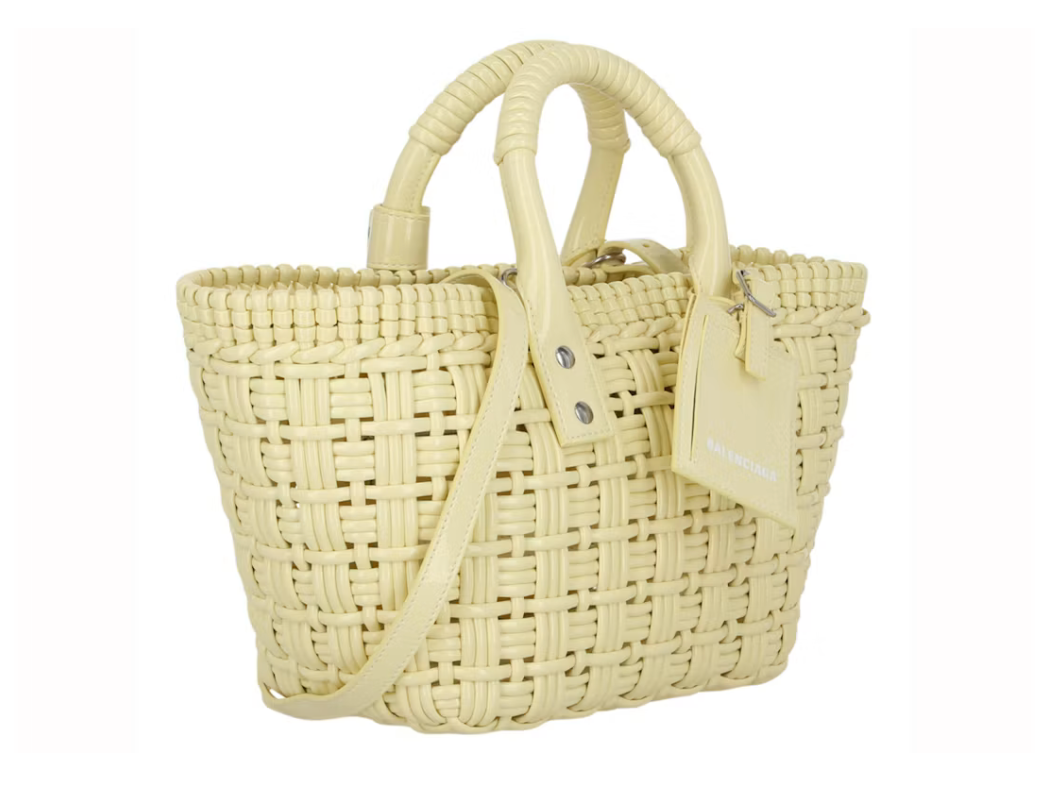 Balenciaga Bistro Strap Basket XS Yellow en matière tressée jaune avec deux anses roulées, étiquette Balenciaga et bandoulière amovible.