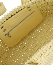 Balenciaga Bistro Strap Basket XS Yellow en matière tressée jaune avec deux anses roulées, étiquette Balenciaga et bandoulière amovible.