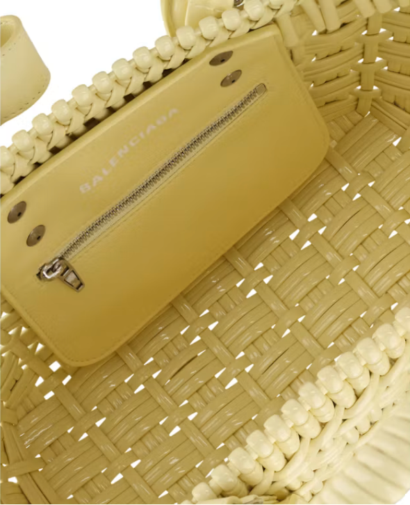Balenciaga Bistro Strap Basket XS Yellow en matière tressée jaune avec deux anses roulées, étiquette Balenciaga et bandoulière amovible.