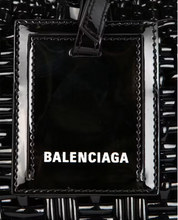 Balenciaga Bistro XS Basket Top Handle Bag Black en matière noire brillante avec deux anses roulées, étiquette siglée et bandoulière amovible.