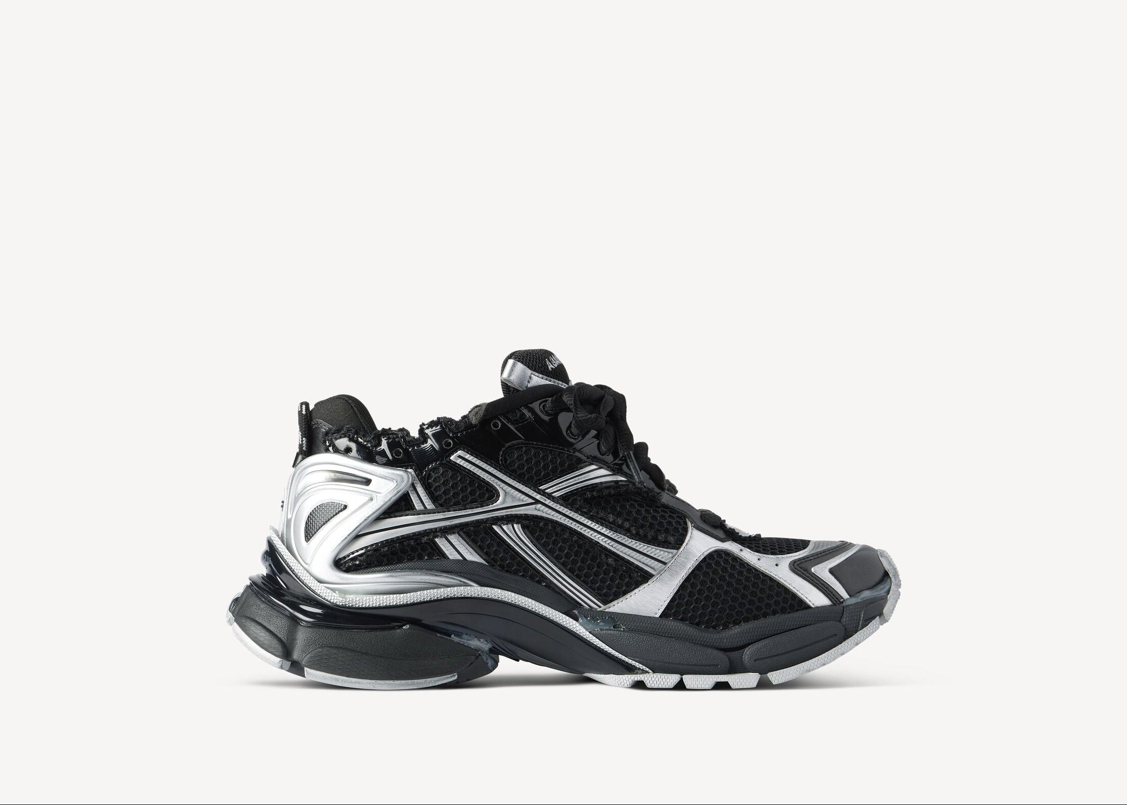 Balenciaga Runner Black Silver avec tige en mesh respirant, empiècements en cuir et matières synthétiques noirs et argentés, silhouette running déstructurée et semelle épaisse en caoutchouc.