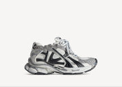 Balenciaga Runner Grey White Black avec tige en mesh respirant, empiècements en cuir gris, blanc et noir, semelle intermédiaire en mousse et silhouette inspirée du running rétro.