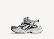 Balenciaga Runner Grey White Black avec tige en mesh respirant, empiècements en cuir gris, blanc et noir, semelle intermédiaire en mousse et silhouette inspirée du running rétro.