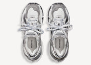 Balenciaga Runner Grey White Black avec tige en mesh respirant, empiècements en cuir gris, blanc et noir, semelle intermédiaire en mousse et silhouette inspirée du running rétro.