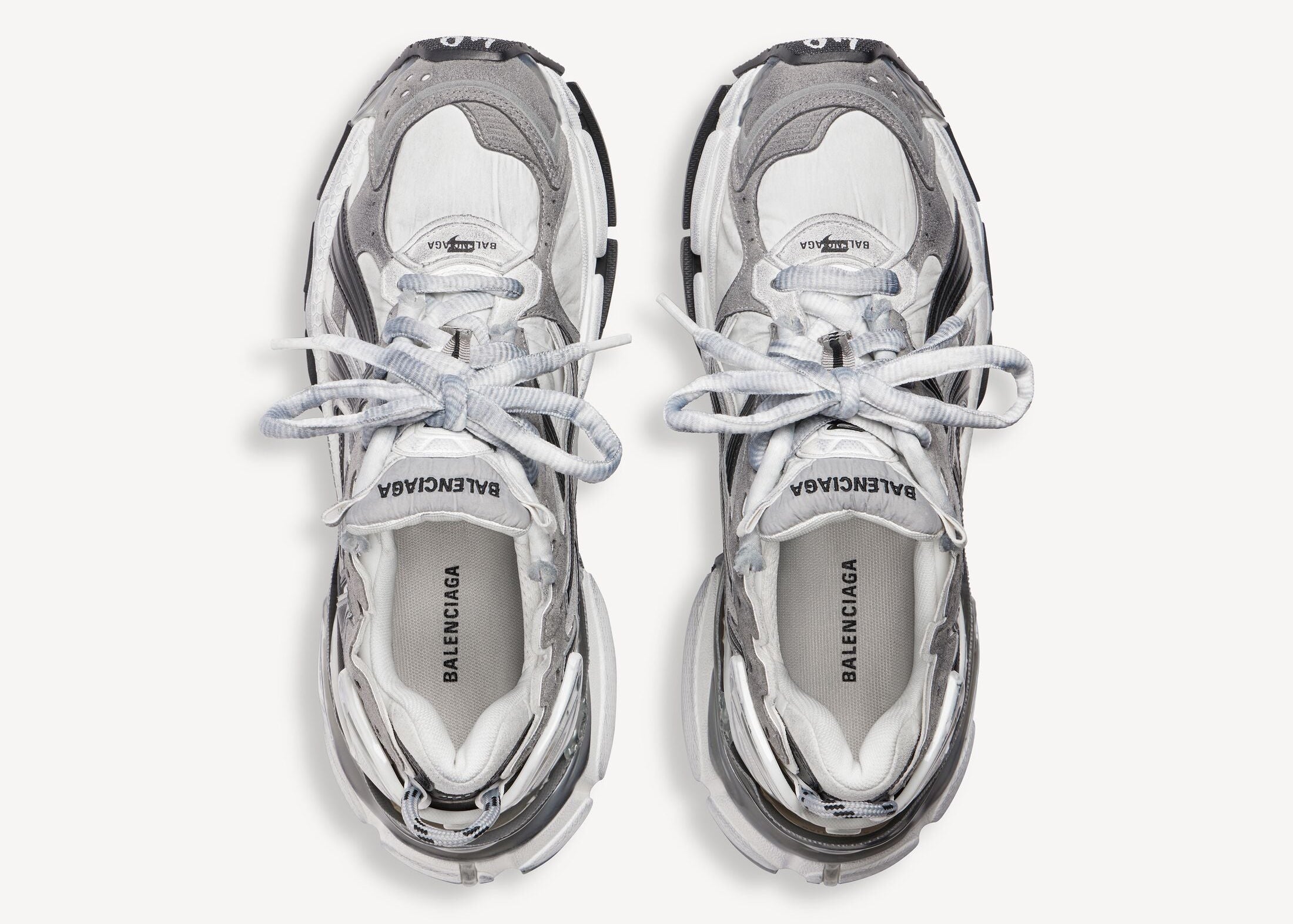 Balenciaga Runner Grey White Black avec tige en mesh respirant, empiècements en cuir gris, blanc et noir, semelle intermédiaire en mousse et silhouette inspirée du running rétro.