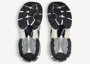 Balenciaga Runner Grey White Black avec tige en mesh respirant, empiècements en cuir gris, blanc et noir, semelle intermédiaire en mousse et silhouette inspirée du running rétro.
