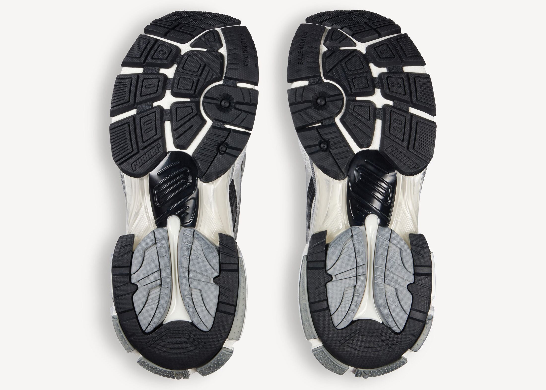 Balenciaga Runner Grey White Black avec tige en mesh respirant, empiècements en cuir gris, blanc et noir, semelle intermédiaire en mousse et silhouette inspirée du running rétro.