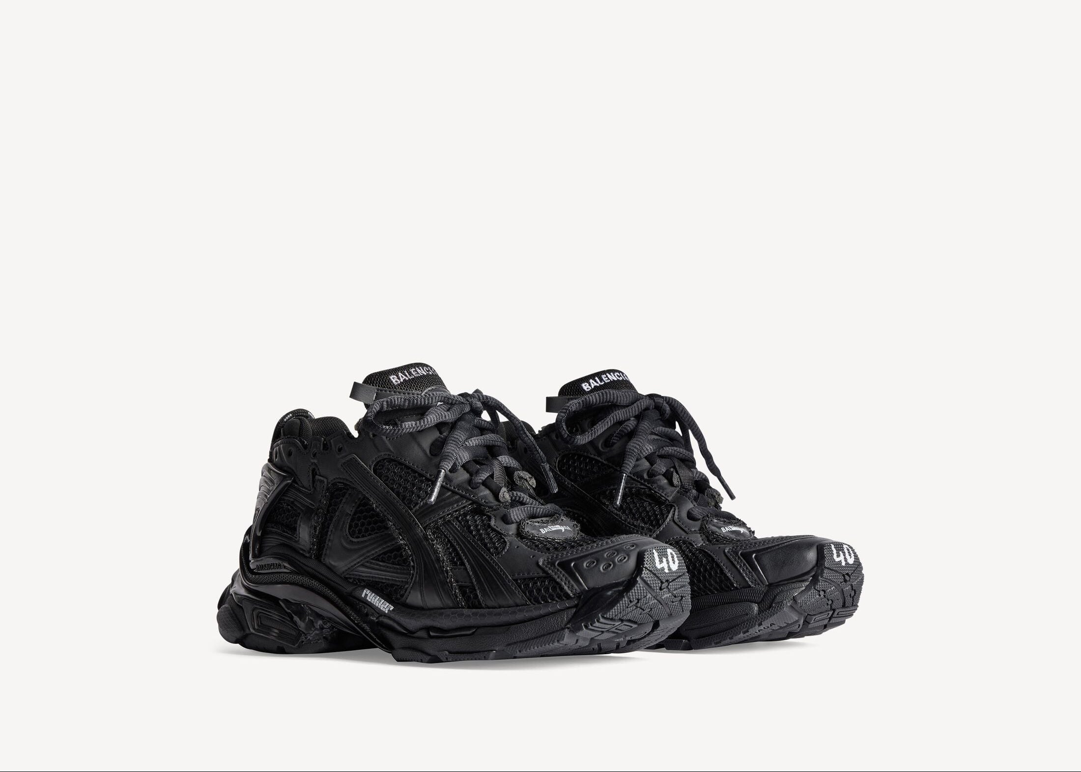 Balenciaga Runner Matte Black avec tige en mesh respirant, empiècements en cuir et matières synthétiques noirs, finition mate et semelle épaisse en caoutchouc au design running.