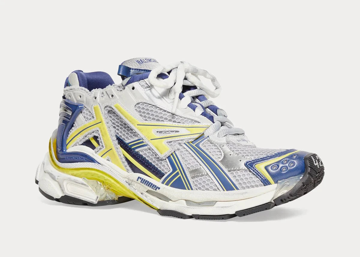 Balenciaga Runner White Blue Yellow Grey Black avec tige en mesh respirant, empiècements en cuir multicolore, semelle intermédiaire en mousse et silhouette inspirée du running vintage.