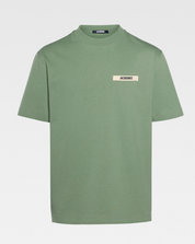 Jacquemus Le T-shirt Gros Grain Light Green, tee-shirt en coton vert clair premium, avec bande Gros Grain ton sur ton sur la poitrine, coupe ample wide cut, col rond en bord-côte et finitions renforcées.