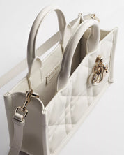 Dior Mini Dior Book Macrocannage Calfskin Tote Latte, mini sac cabas en cuir de veau blanc crème, surpiqûres Macrocannage et charms D.I.O.R. dorés vu de 3/4 haut. 