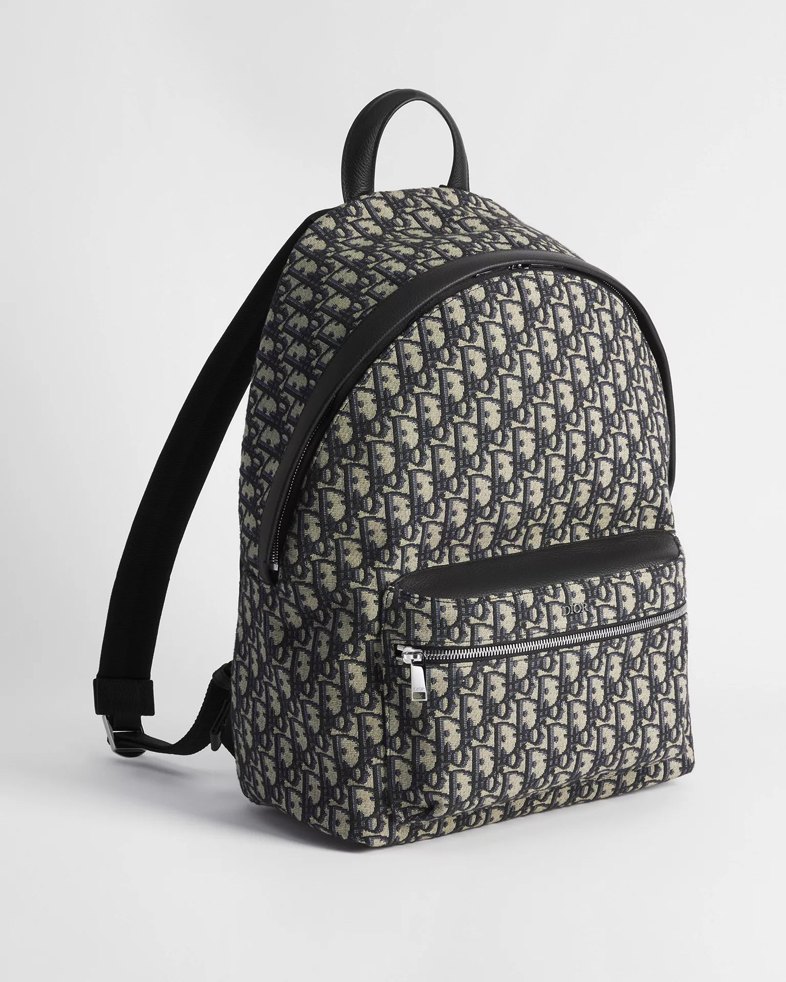 Dior Rider Backpack Oblique Blue/Black, sac à dos en toile jacquard à motif Dior Oblique, finitions en cuir sombre, poche avant zippée et bretelles réglables vu de 3/4 face. 