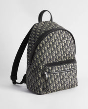 Dior Rider Backpack Oblique Blue/Black, sac à dos en toile jacquard à motif Dior Oblique, finitions en cuir sombre, poche avant zippée et bretelles réglables vu de 3/4 face. 