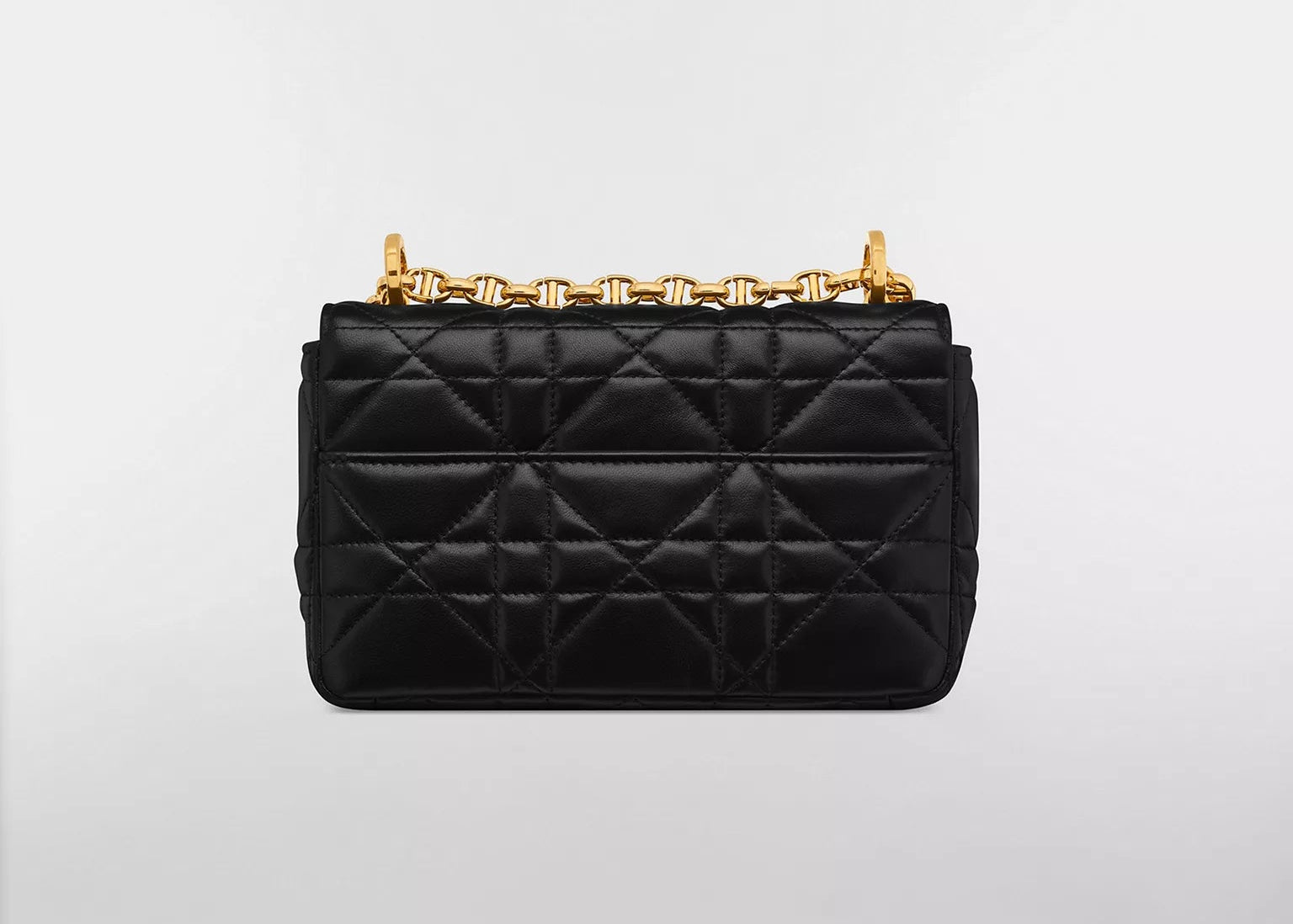 Dior Small Caro Supple Cannage Calfskin Bag Black, sac à rabat en cuir de veau noir matelassé Cannage, fermoir CD doré vieilli et bandoulière chaîne vu de derrière. 