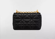 Dior Small Caro Supple Cannage Calfskin Bag Black, sac à rabat en cuir de veau noir matelassé Cannage, fermoir CD doré vieilli et bandoulière chaîne vu de derrière. 
