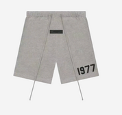 Fear of God Essentials 1977 Short Grey en tissu gris doux, avec coupe décontractée, taille élastique ajustable, cordon de serrage et marquage 1977 contrastant.