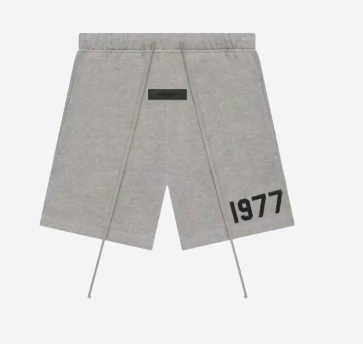 Fear of God Essentials 1977 Short Grey en tissu gris doux, avec coupe décontractée, taille élastique ajustable, cordon de serrage et marquage 1977 contrastant.