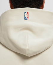 Fear of God Essentials NBA 90's Hoodie Cream White, hoodie Cream White issu de la collaboration Fear of God Essentials x NBA avec coupe ample, inspiration années 90 et finitions premium.