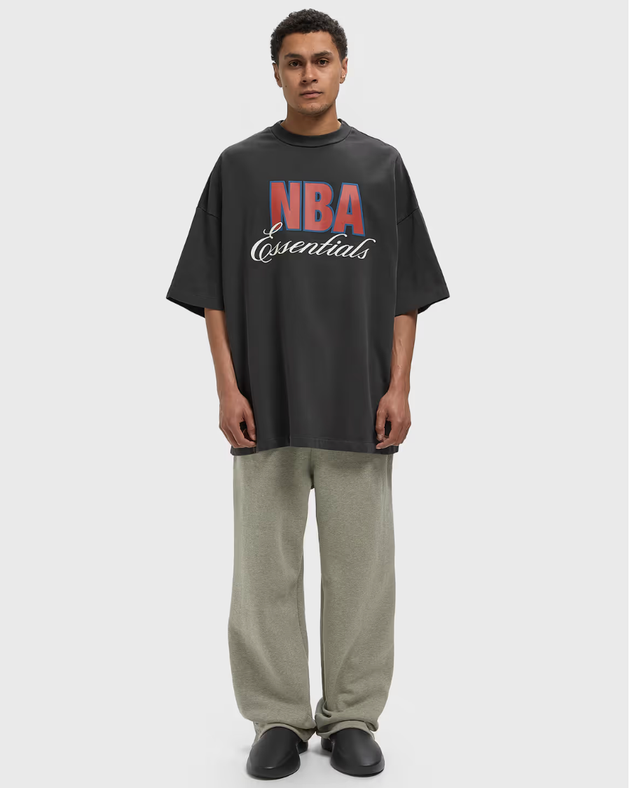 Fear of God Essentials NBA 90's Tee Black, t-shirt noir en coton premium issu de la collaboration Fear of God Essentials x NBA, inspiré du basketball des années 90.
