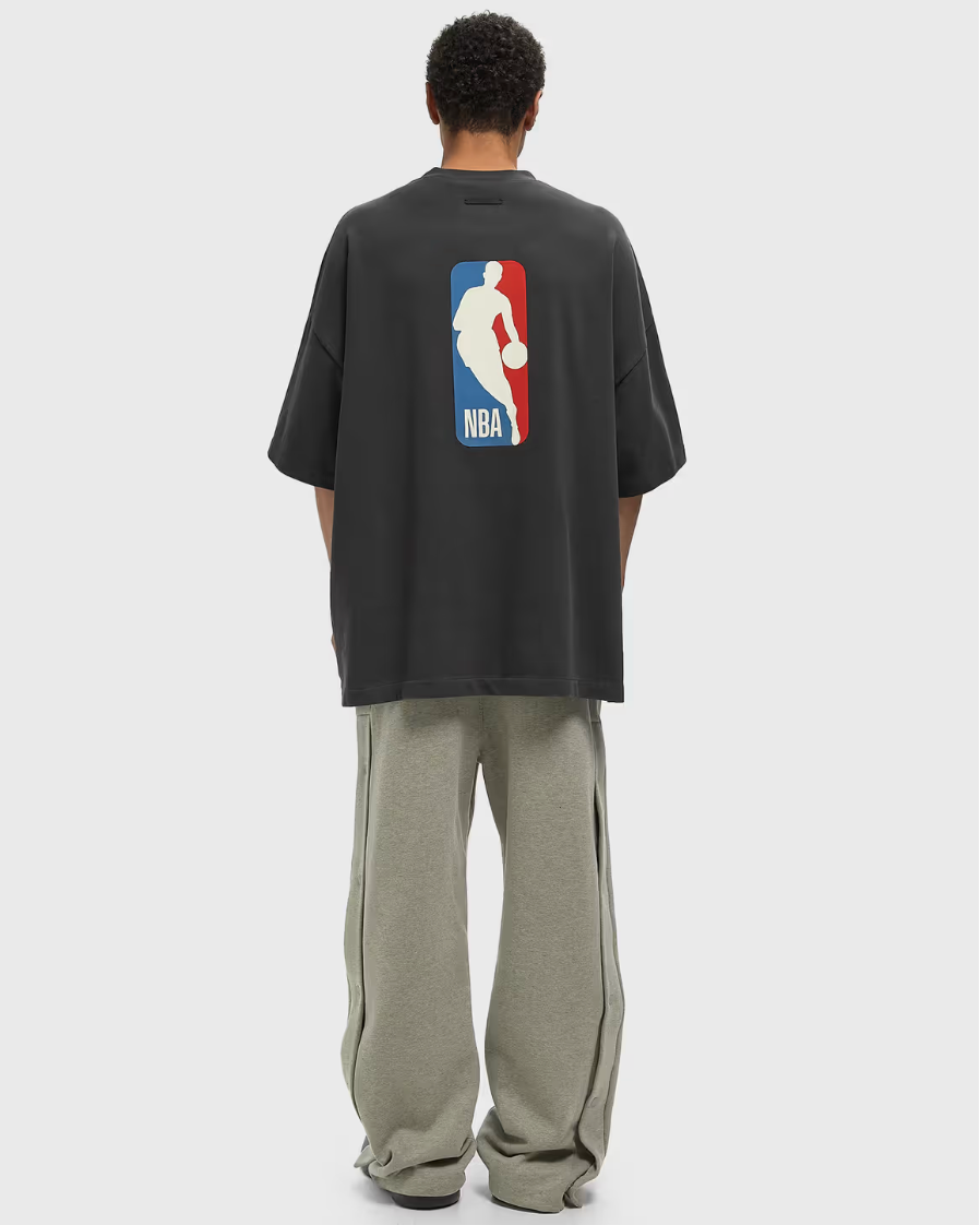 Fear of God Essentials NBA 90's Tee Black, t-shirt noir en coton premium issu de la collaboration Fear of God Essentials x NBA, inspiré du basketball des années 90.