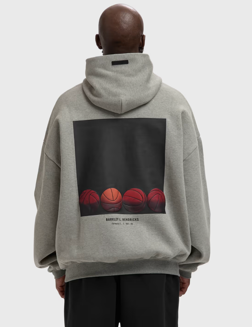 Fear of God Essentials NBA x Barkley Hendricks 90s Hoodie Concrete Heather, hoodie gris Concrete Heather issu de la collaboration Fear of God Essentials x NBA x Barkley Hendricks avec coupe ample et finitions premium.