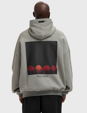 Fear of God Essentials NBA x Barkley Hendricks 90s Hoodie Concrete Heather, hoodie gris Concrete Heather issu de la collaboration Fear of God Essentials x NBA x Barkley Hendricks avec coupe ample et finitions premium.