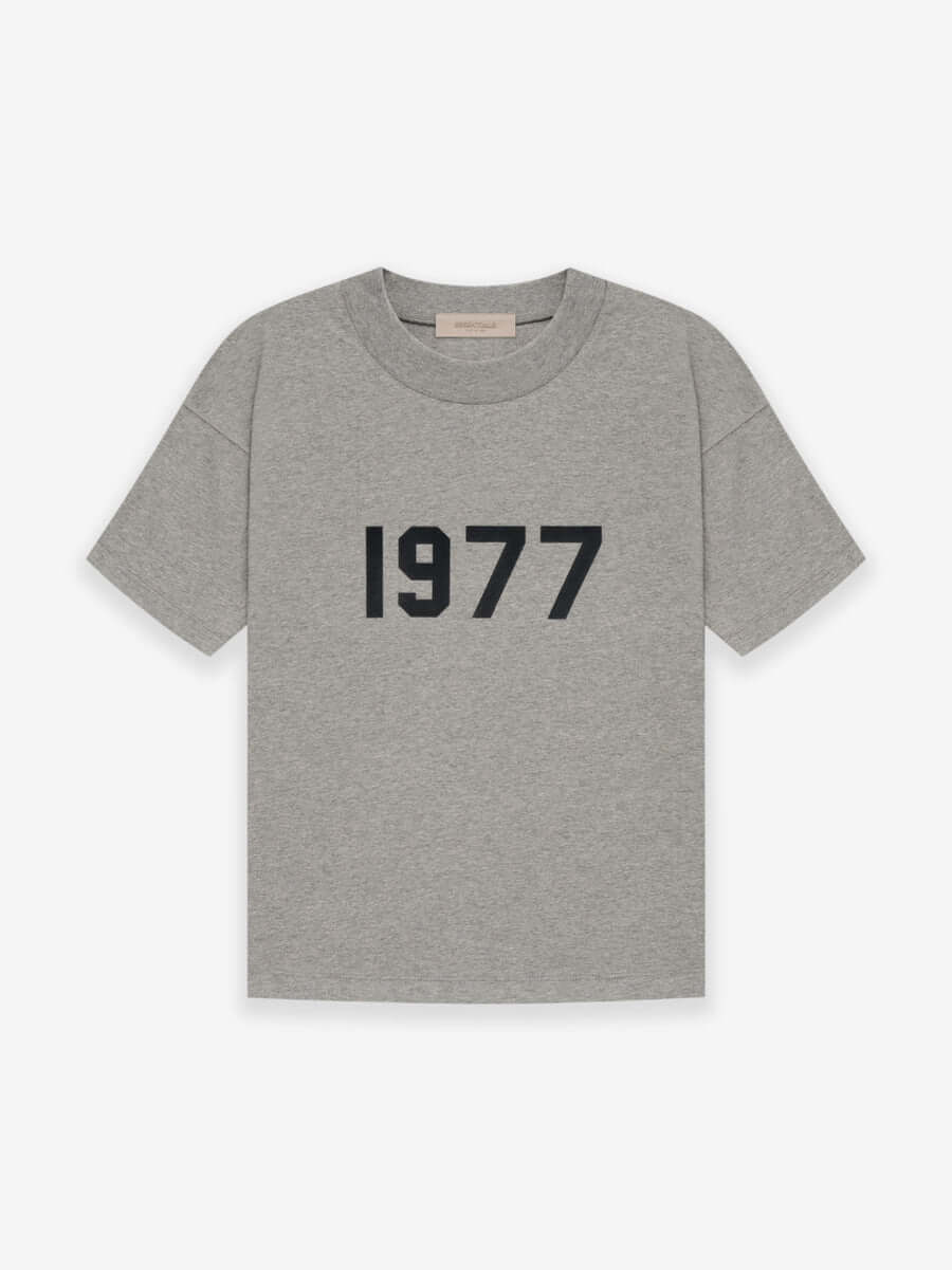 Fear of God Essentials 1977 T-Shirt Grey en tissu gris doux, avec coupe ample, manches courtes, col rond classique et marquage 1977 distinctif.