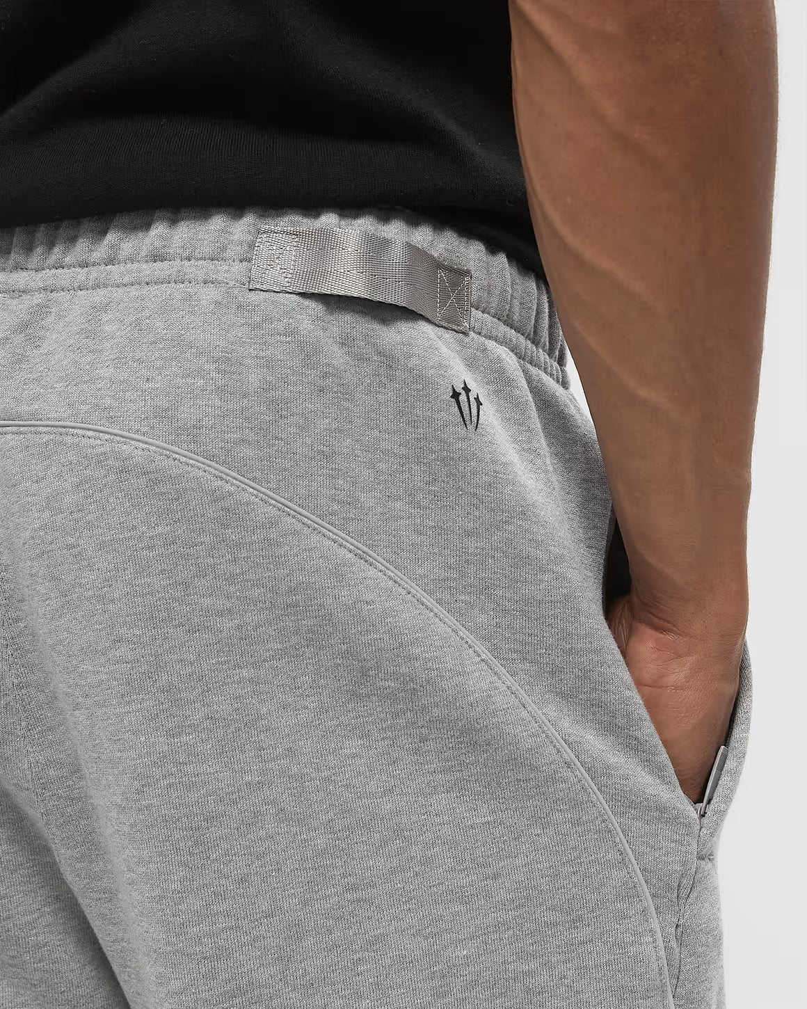 Nike x NOCTA Fleece CS Sweatpant Dark Grey Heather, pantalon fleece gris chiné avec poignets côtelés, poches zippées et détails NOCTA.