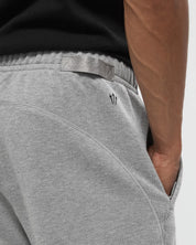 Nike x NOCTA Fleece CS Sweatpant Dark Grey Heather, pantalon fleece gris chiné avec poignets côtelés, poches zippées et détails NOCTA.
