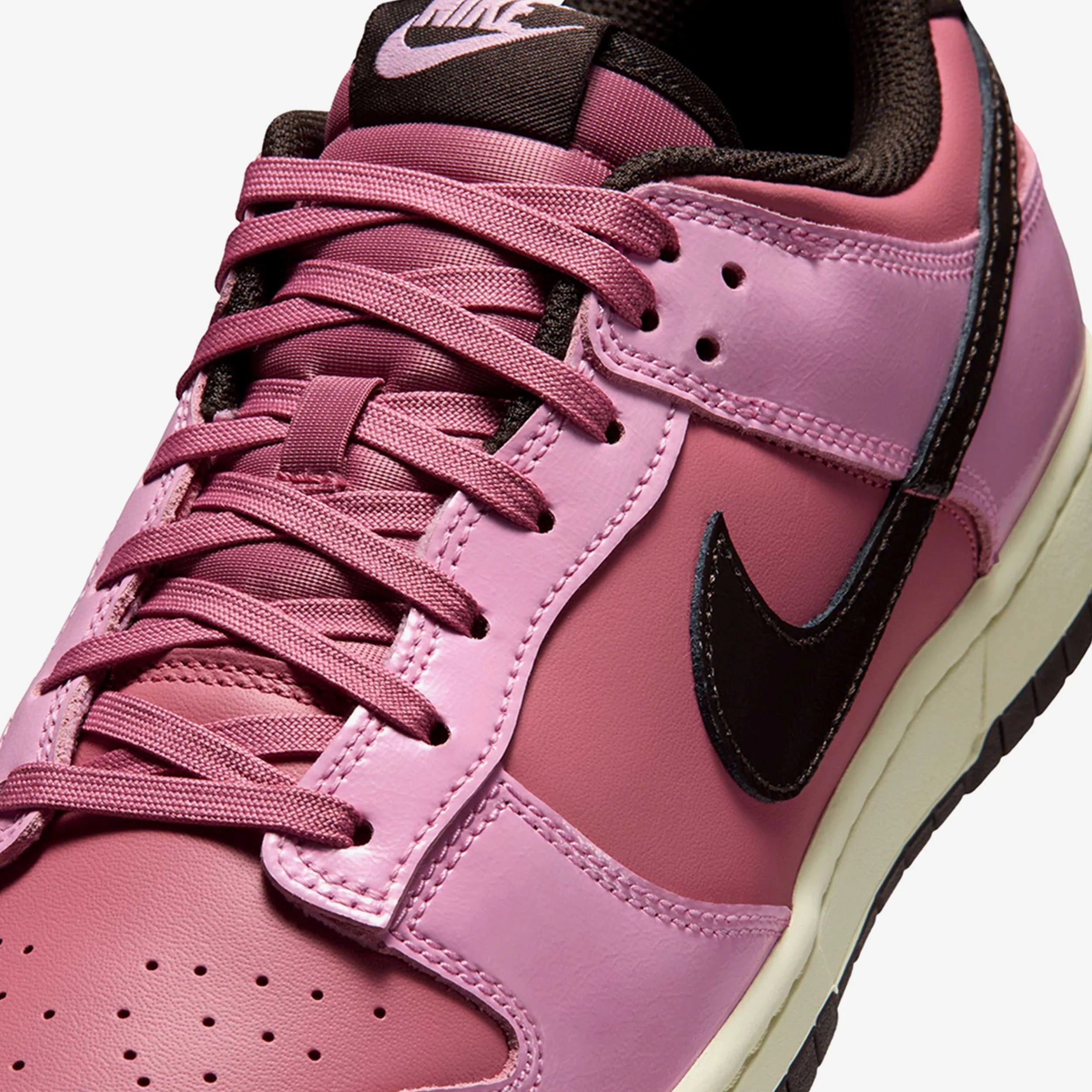 Nike Dunk Low Retro Pink Donut avec tige en cuir rose, empiècements assortis, semelle intermédiaire en mousse et semelle extérieure en caoutchouc au style basketball emblématique.