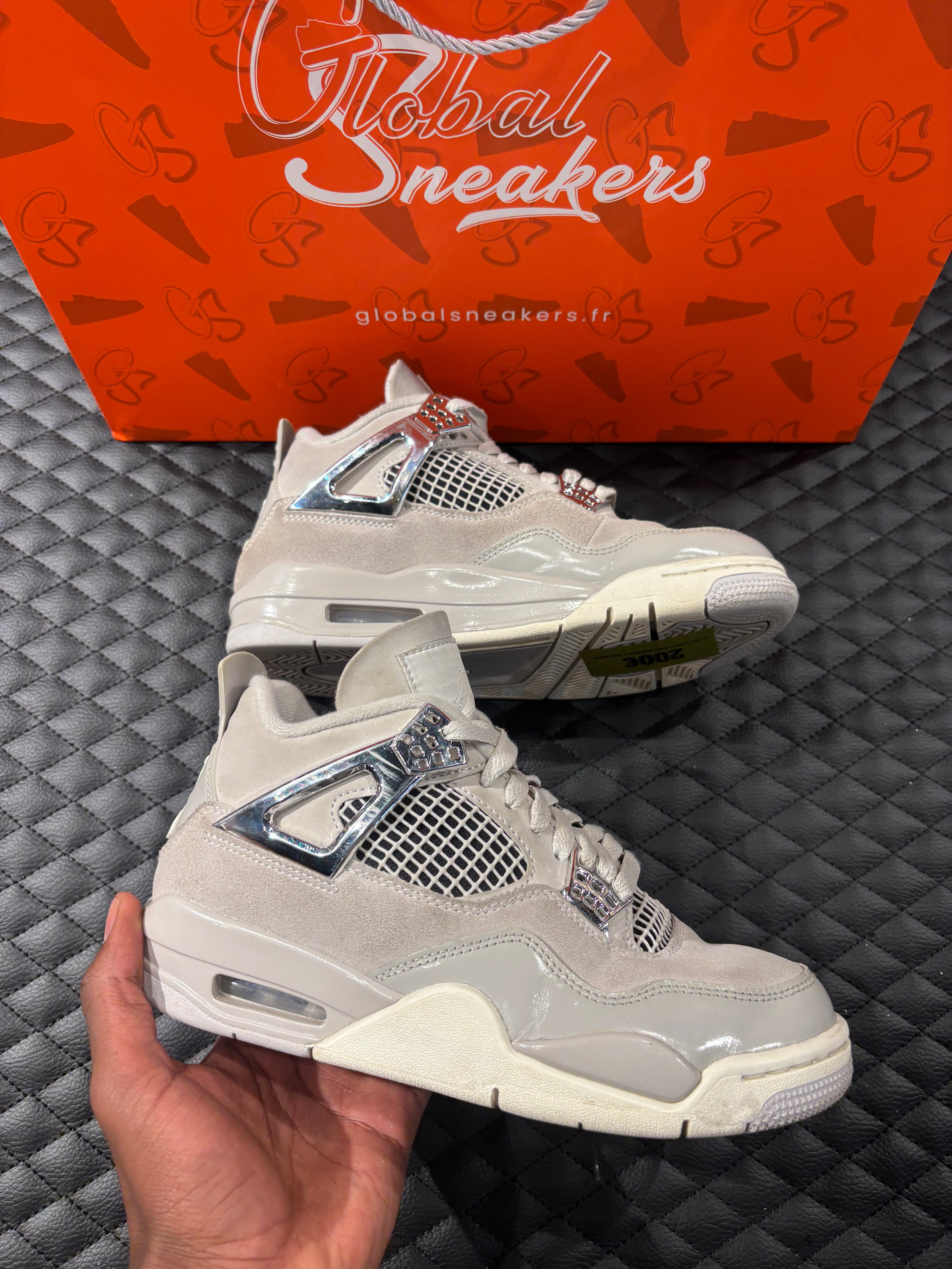 Jordan 4 Rétro Frozen Moments femme d’occasion en état 8,5/10, cuir gris perlé, détails texturés, sneaker sans boîte.