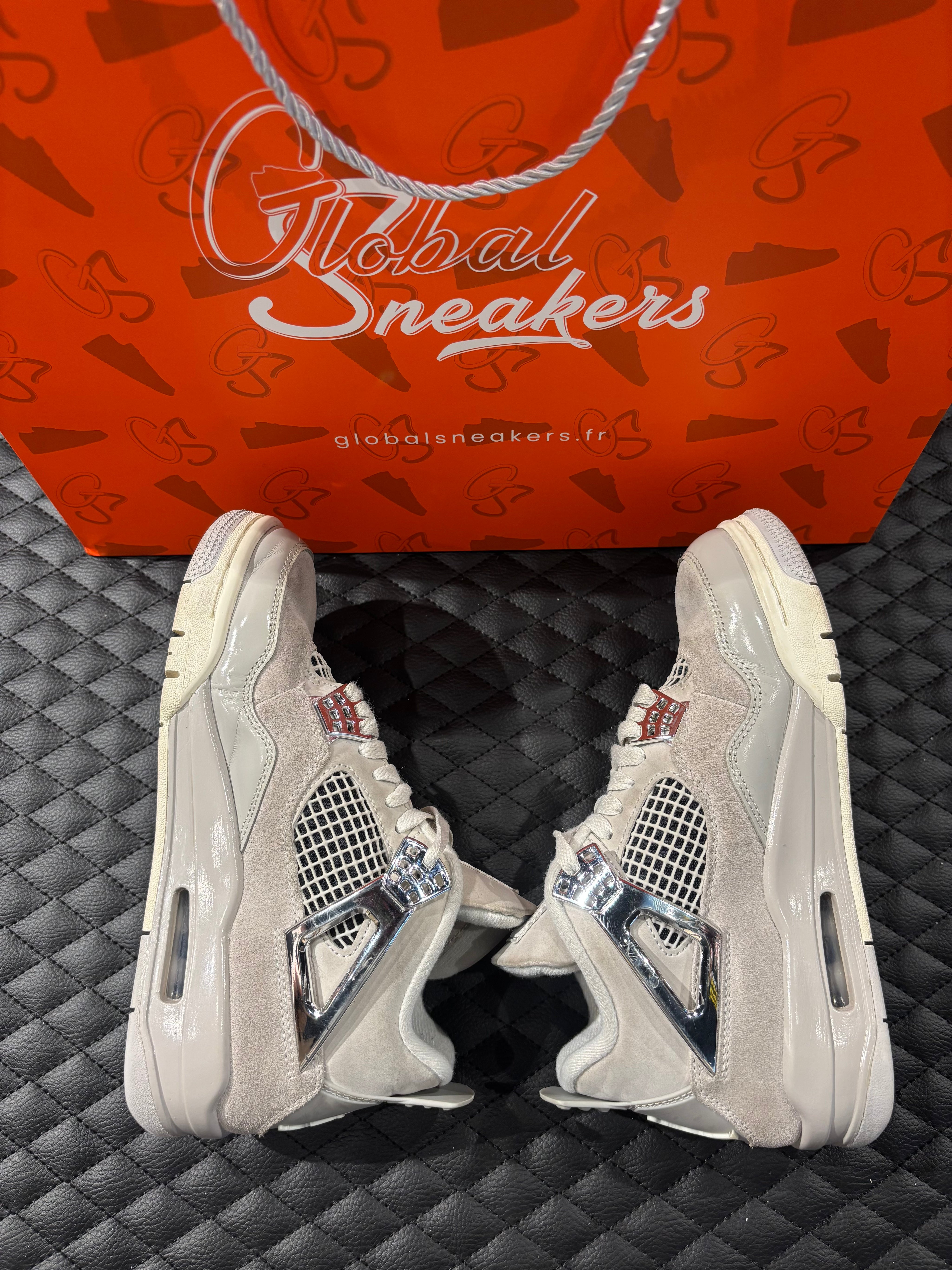 Jordan 4 Rétro Frozen Moments femme d’occasion en état 8,5/10, cuir gris perlé, détails texturés, sneaker sans boîte.