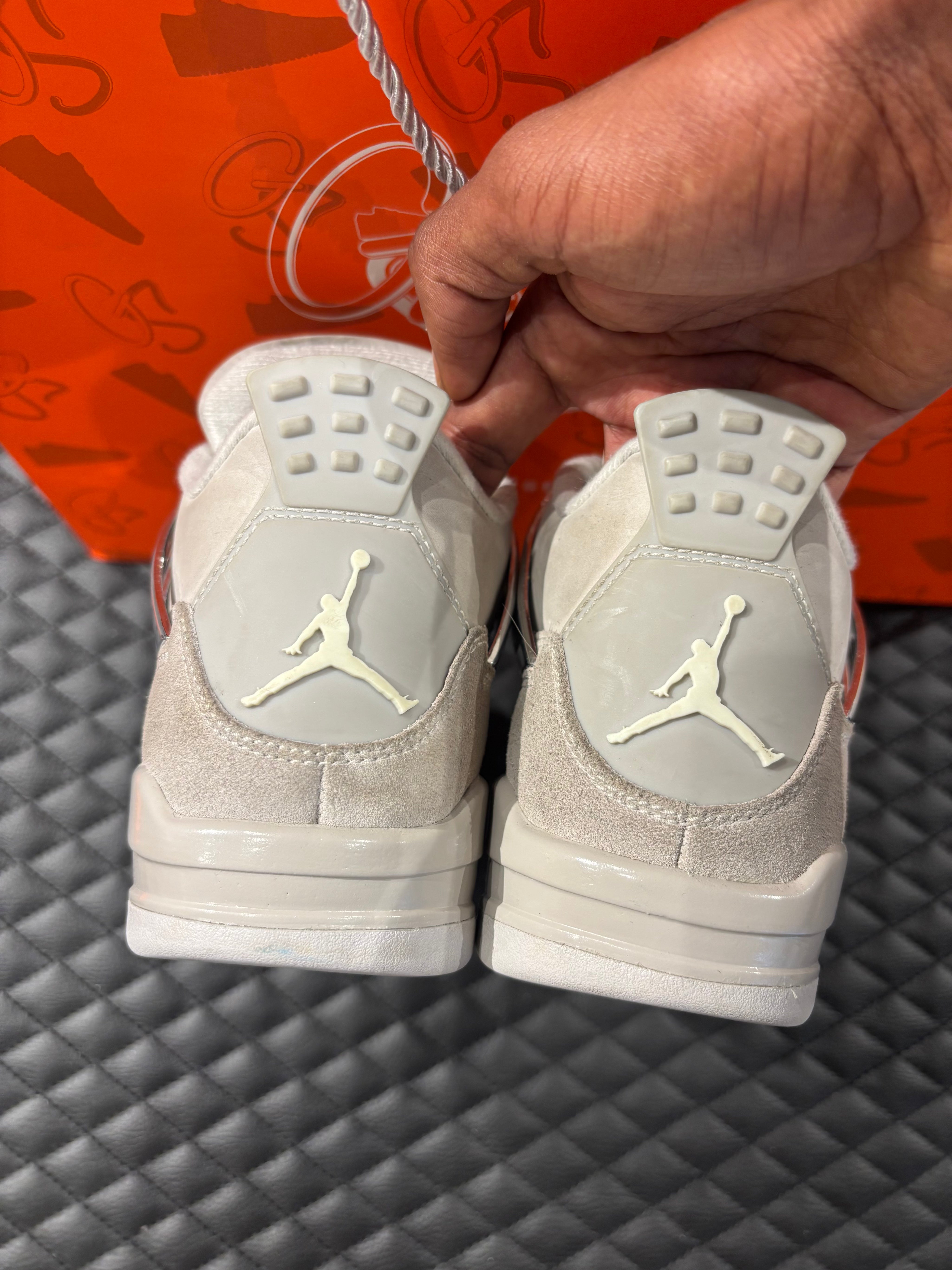 Jordan 4 Rétro Frozen Moments femme d’occasion en état 8,5/10, cuir gris perlé, détails texturés, sneaker sans boîte.