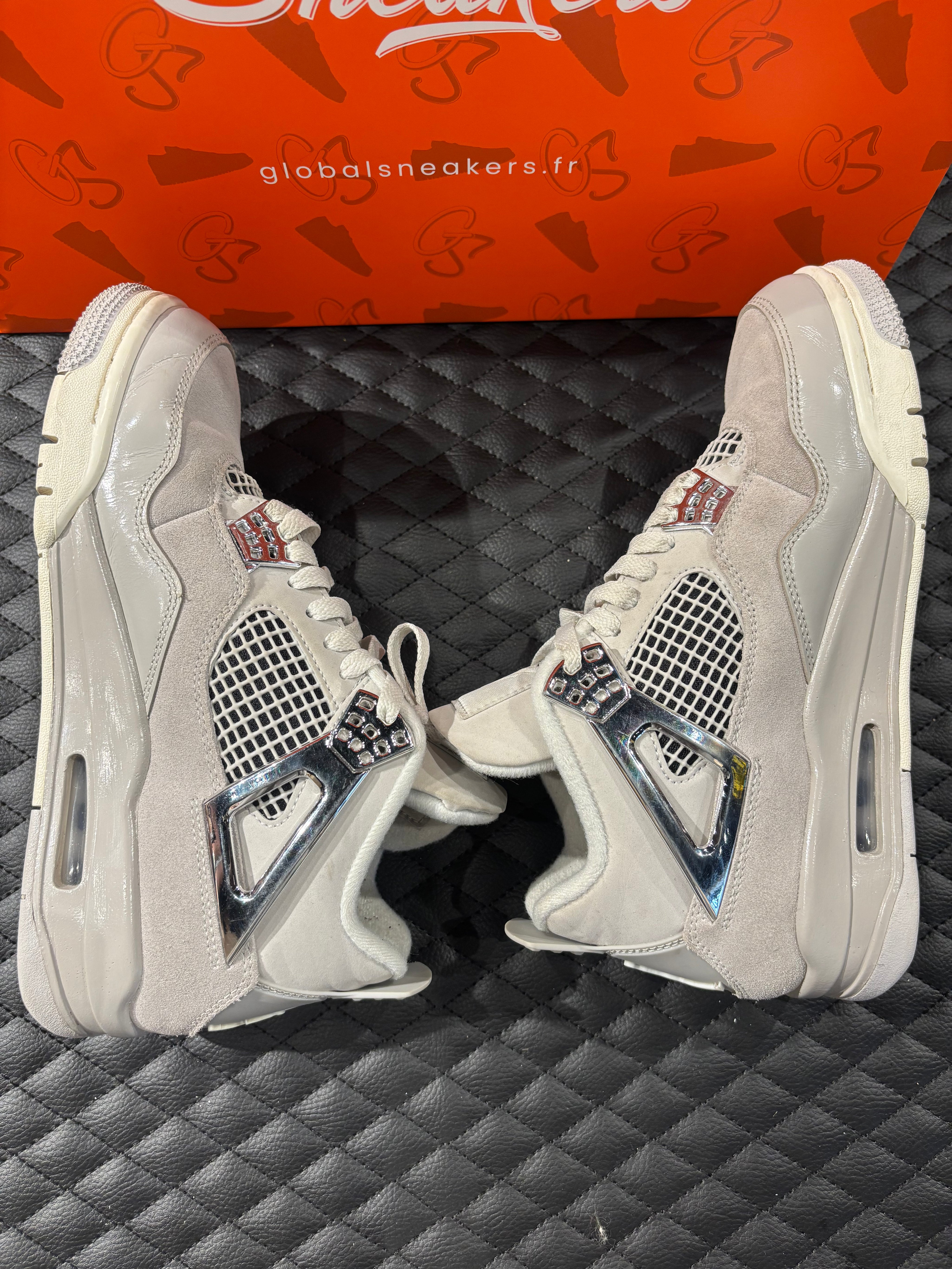 Jordan 4 Rétro Frozen Moments femme d’occasion en état 8,5/10, cuir gris perlé, détails texturés, sneaker sans boîte.