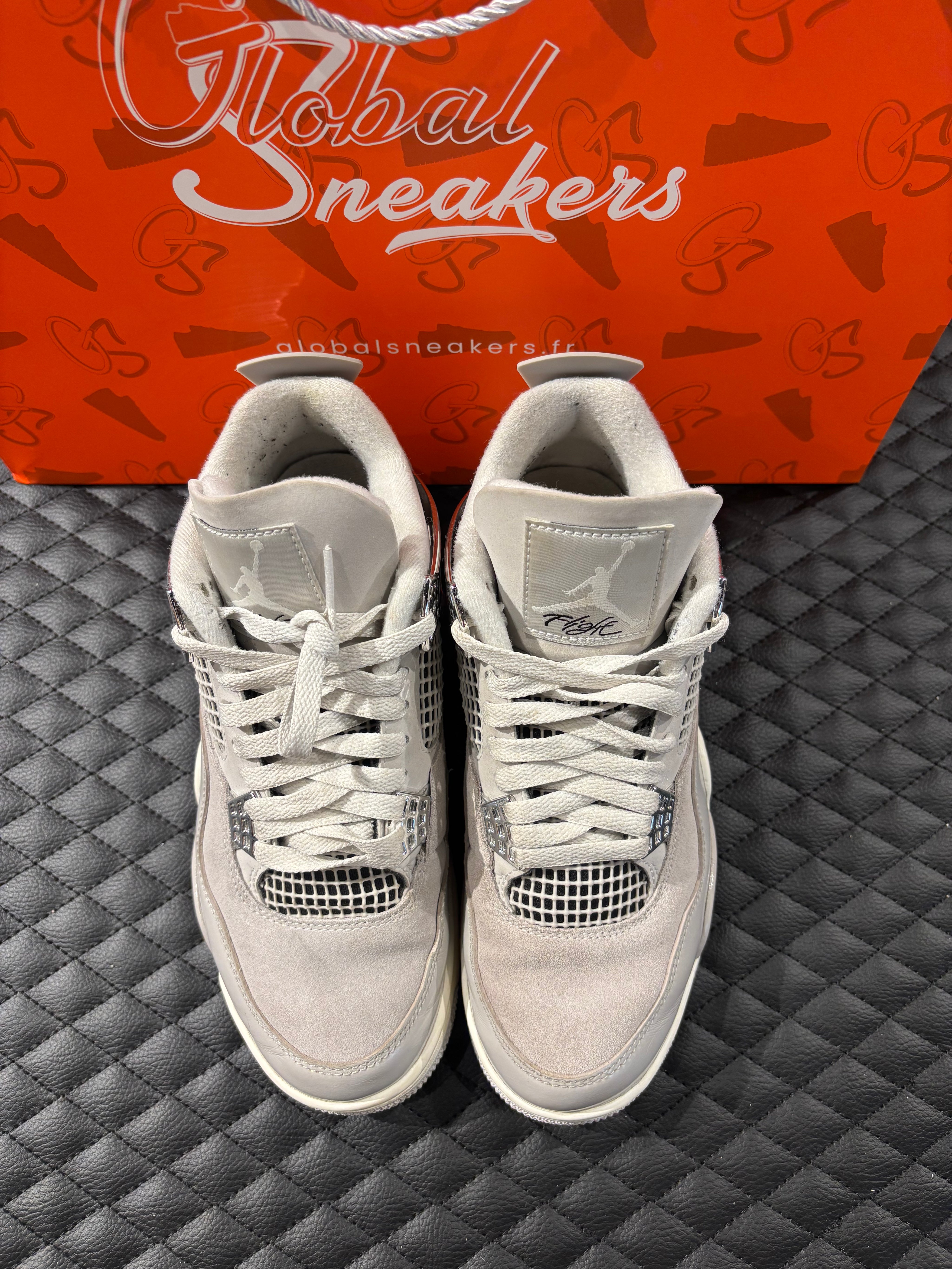 Jordan 4 Rétro Frozen Moments femme d’occasion en état 8,5/10, cuir gris perlé, détails texturés, sneaker sans boîte.