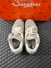 Jordan 4 Rétro Frozen Moments femme d’occasion en état 8,5/10, cuir gris perlé, détails texturés, sneaker sans boîte.