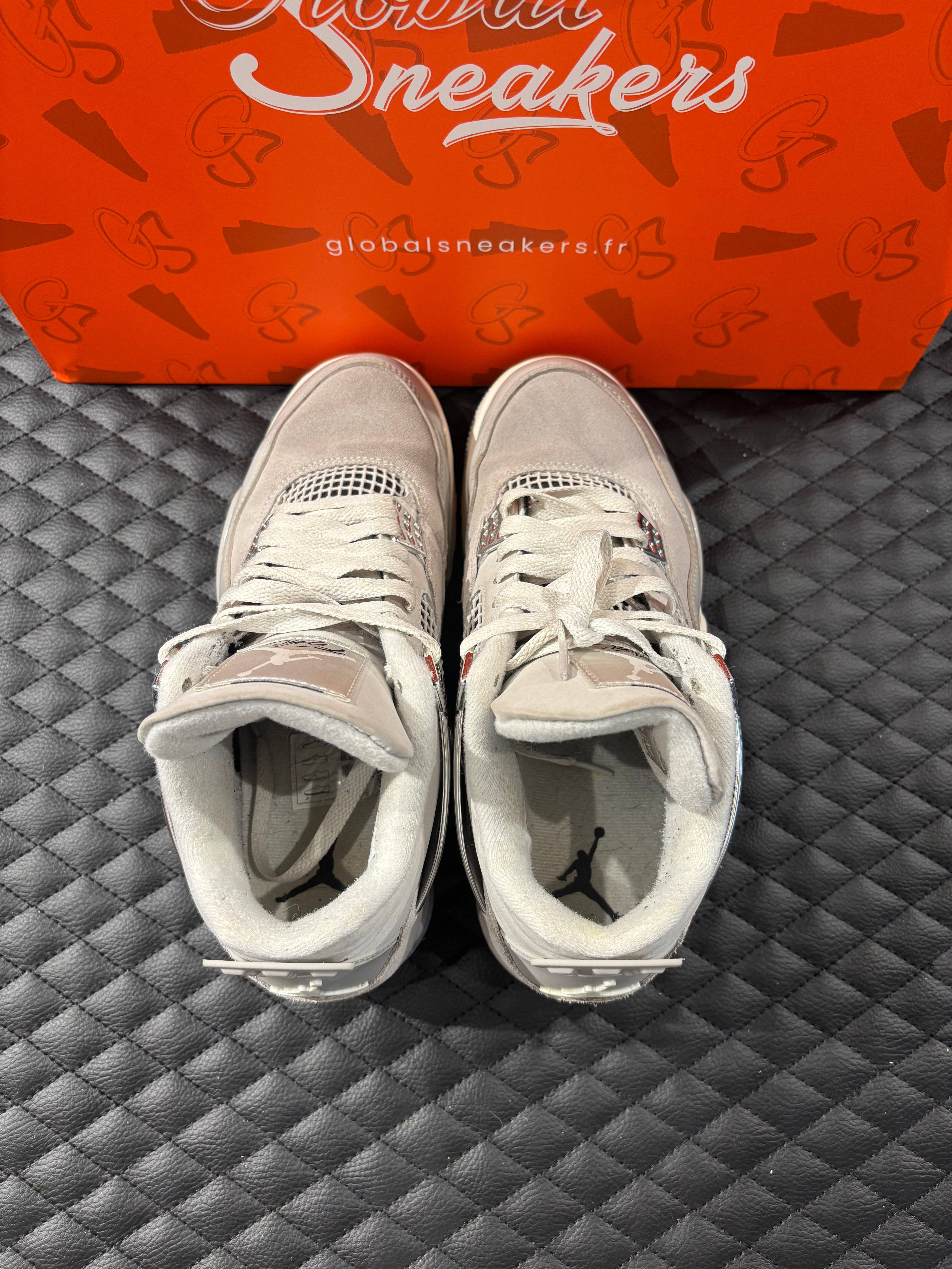 Jordan 4 Rétro Frozen Moments femme d’occasion en état 8,5/10, cuir gris perlé, détails texturés, sneaker sans boîte.