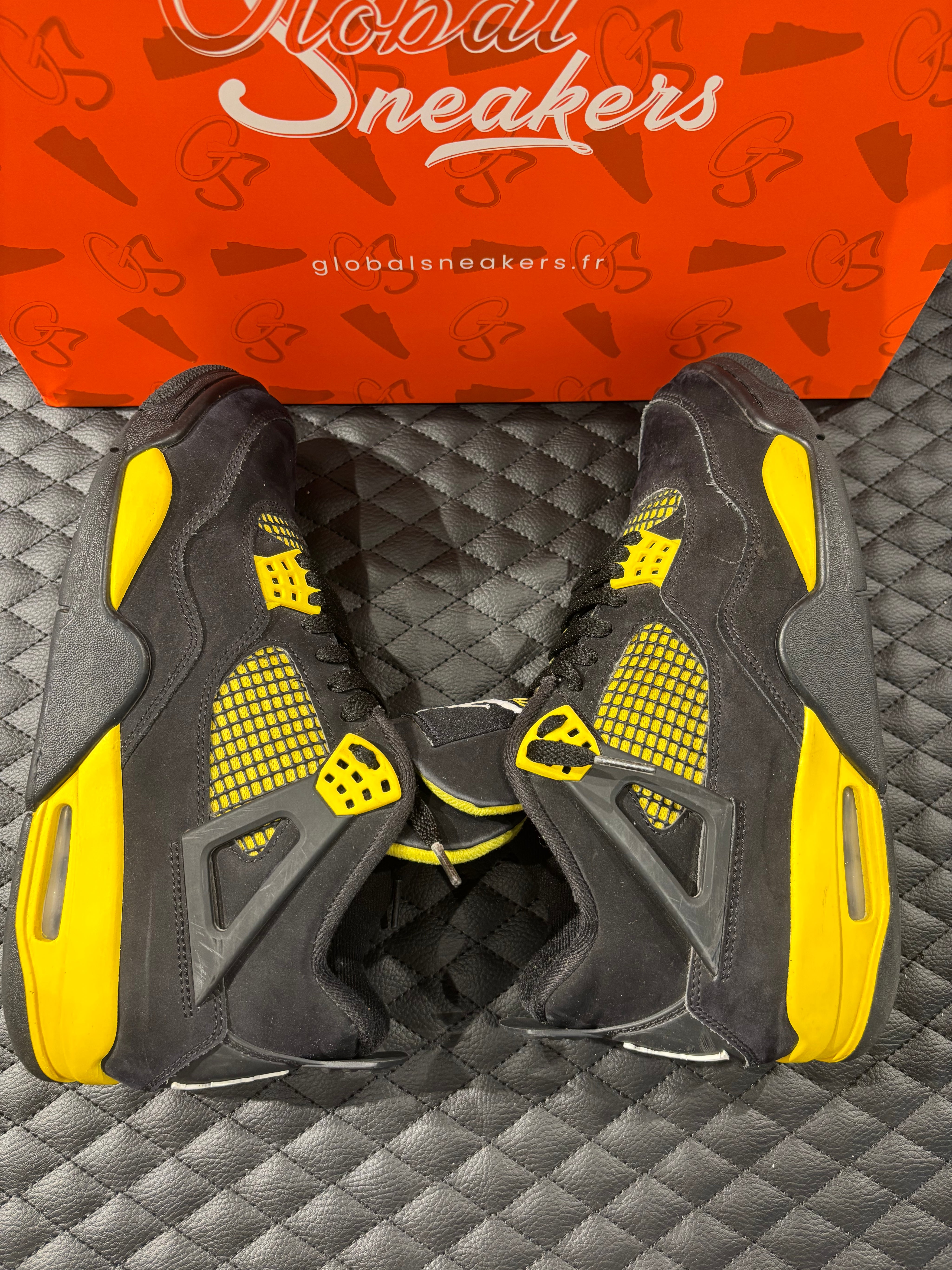 Jordan 4 Rétro Thunder d’occasion en état 8,5/10, suede noir, détails jaunes, sneaker sans boîte.