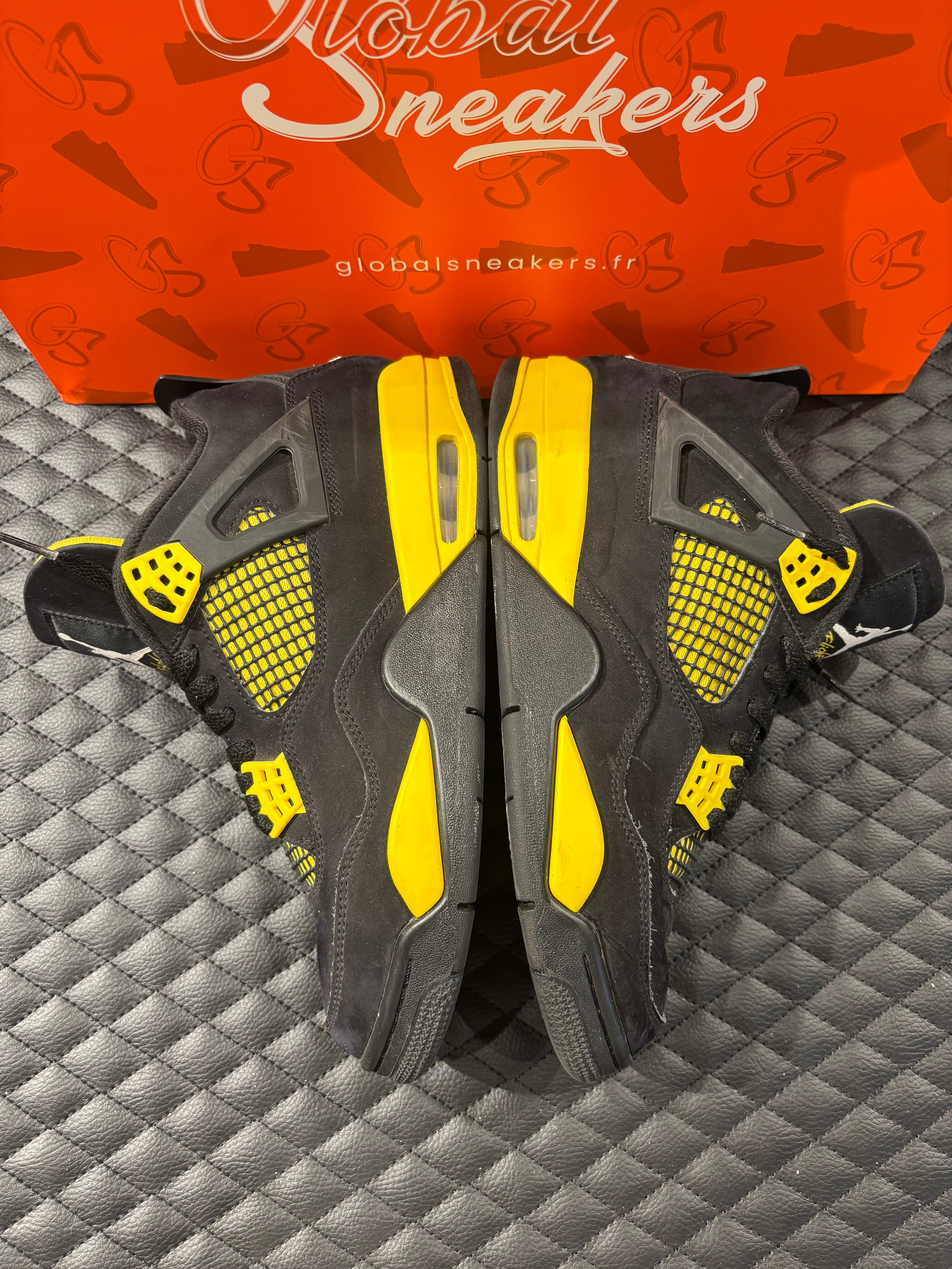 Jordan 4 Rétro Thunder d’occasion en état 8,5/10, suede noir, détails jaunes, sneaker sans boîte.