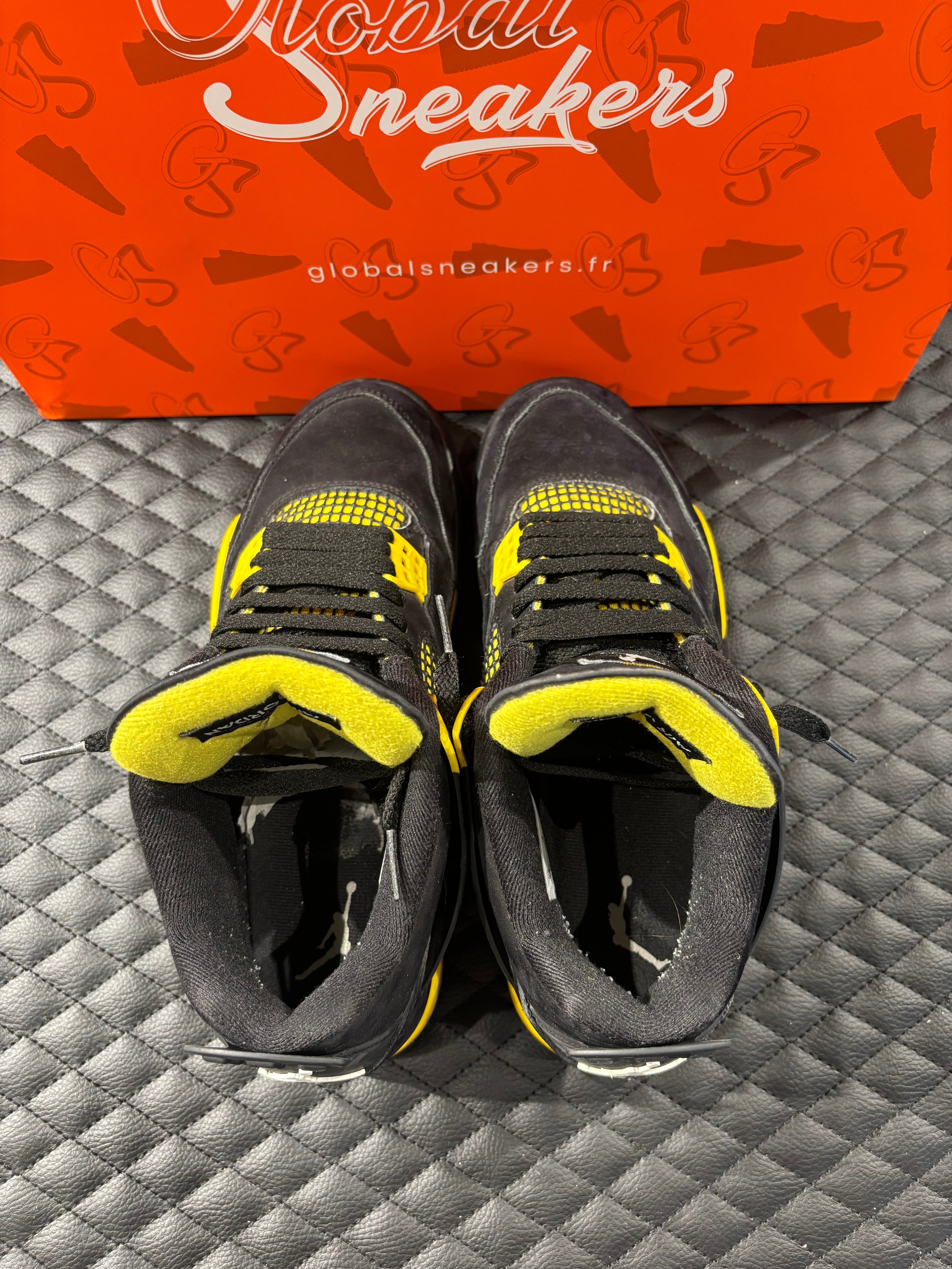Jordan 4 Rétro Thunder d’occasion en état 8,5/10, suede noir, détails jaunes, sneaker sans boîte.