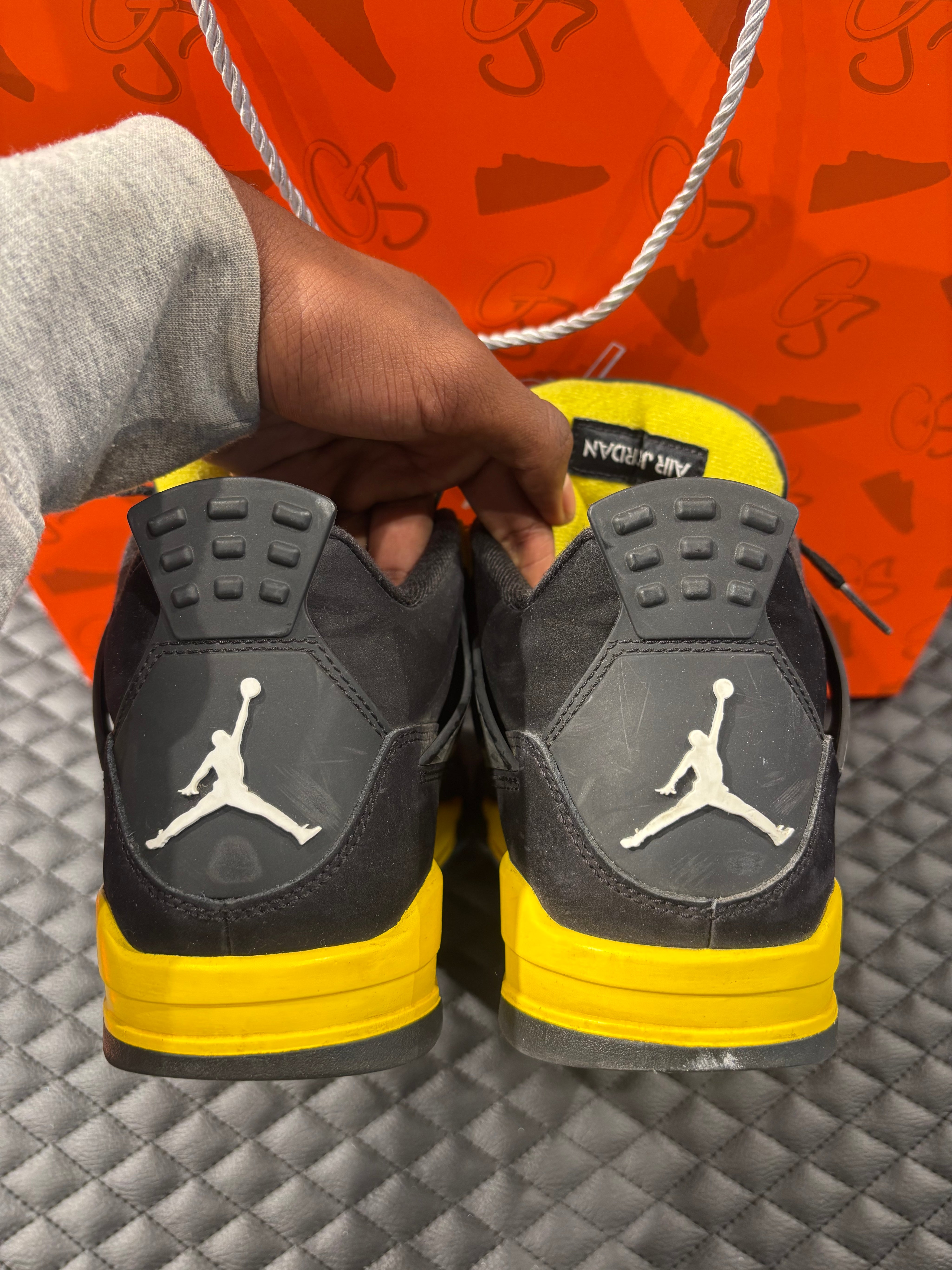 Jordan 4 Rétro Thunder d’occasion en état 8,5/10, suede noir, détails jaunes, sneaker sans boîte.