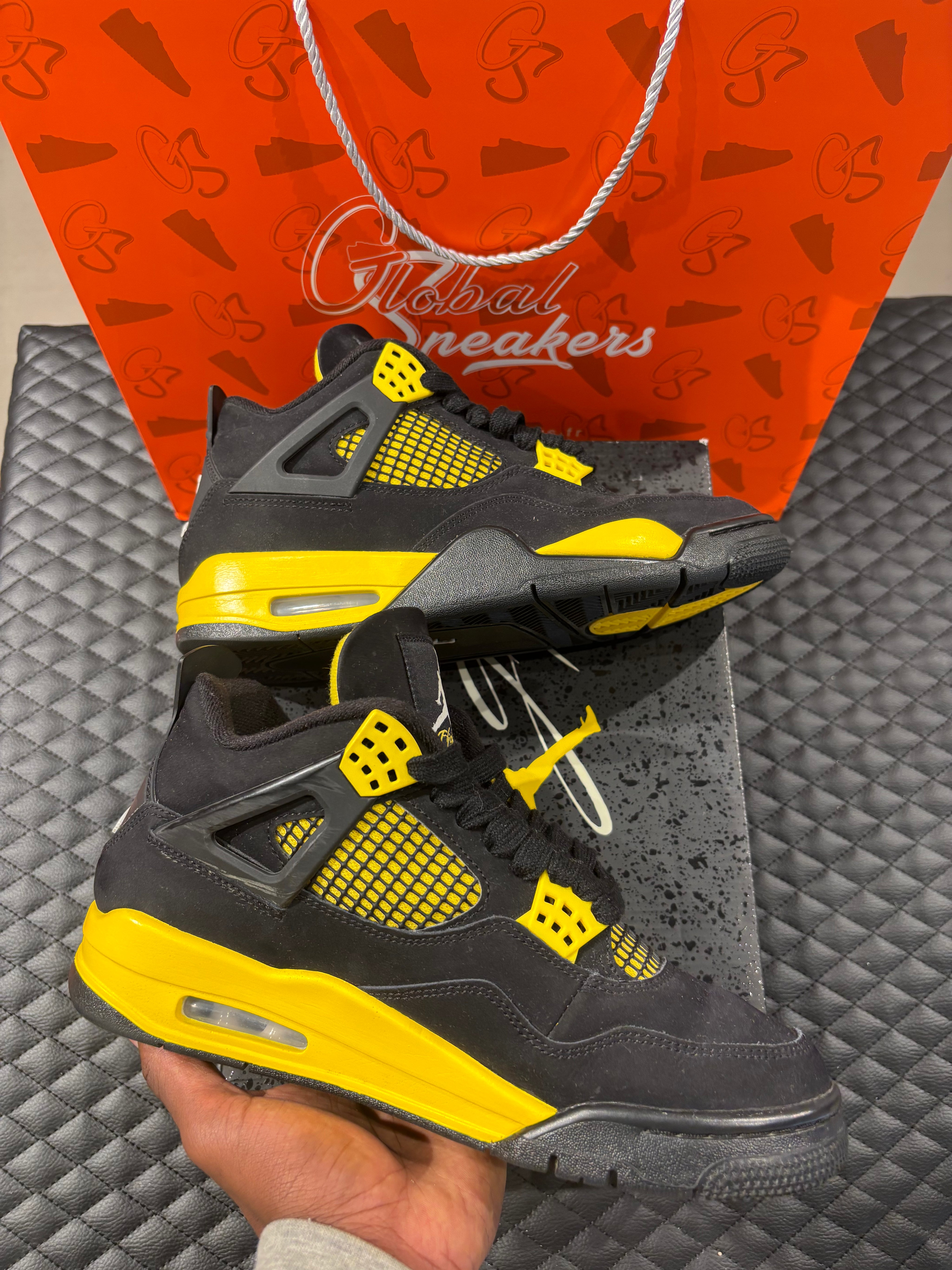 Jordan 4 Rétro Thunder d’occasion en état 8,5/10, suede noir, détails jaunes, sneaker sans boîte.
