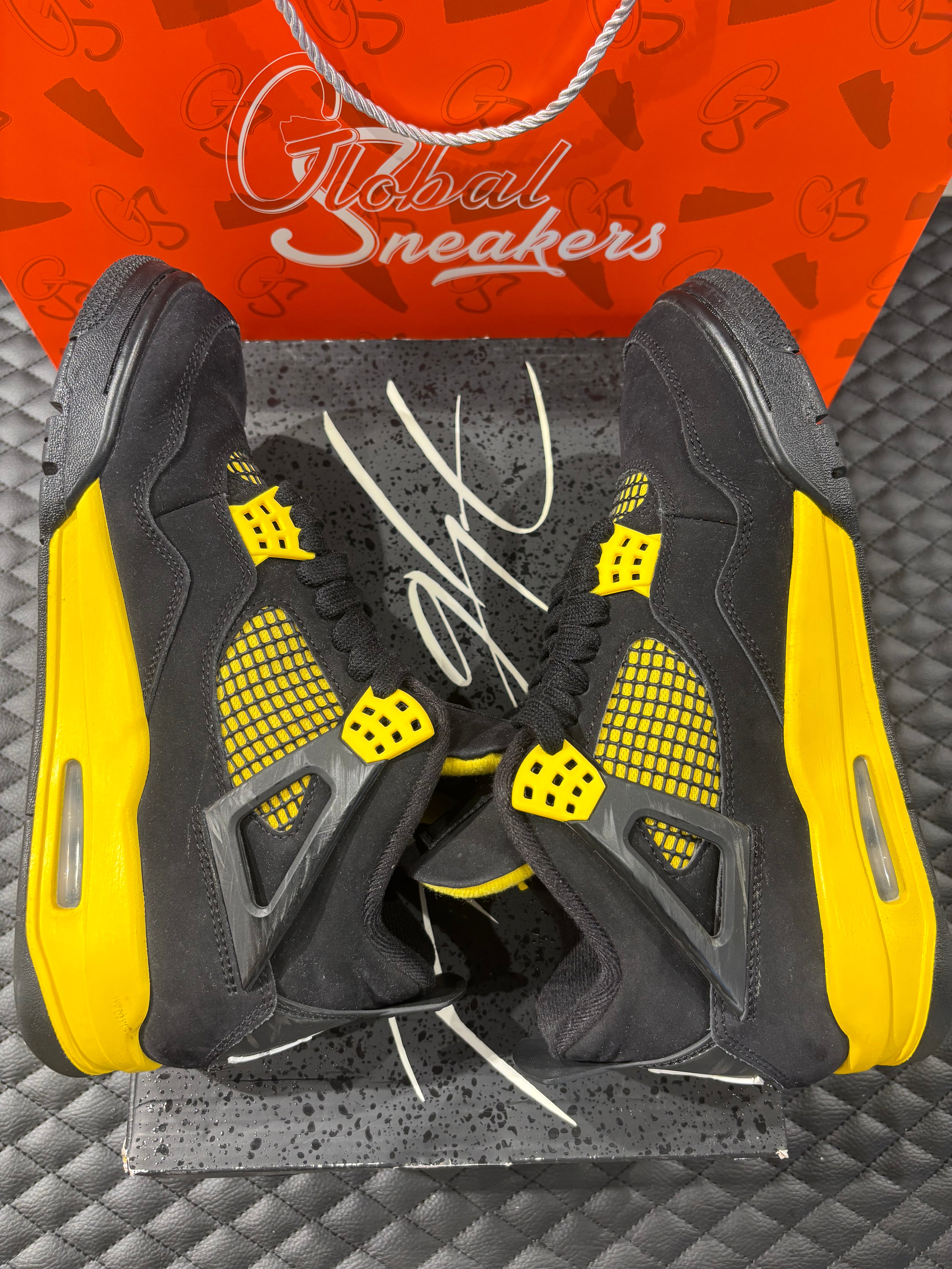 Jordan 4 Rétro Thunder d’occasion en état 8,5/10, suede noir, détails jaunes, sneaker sans boîte.
