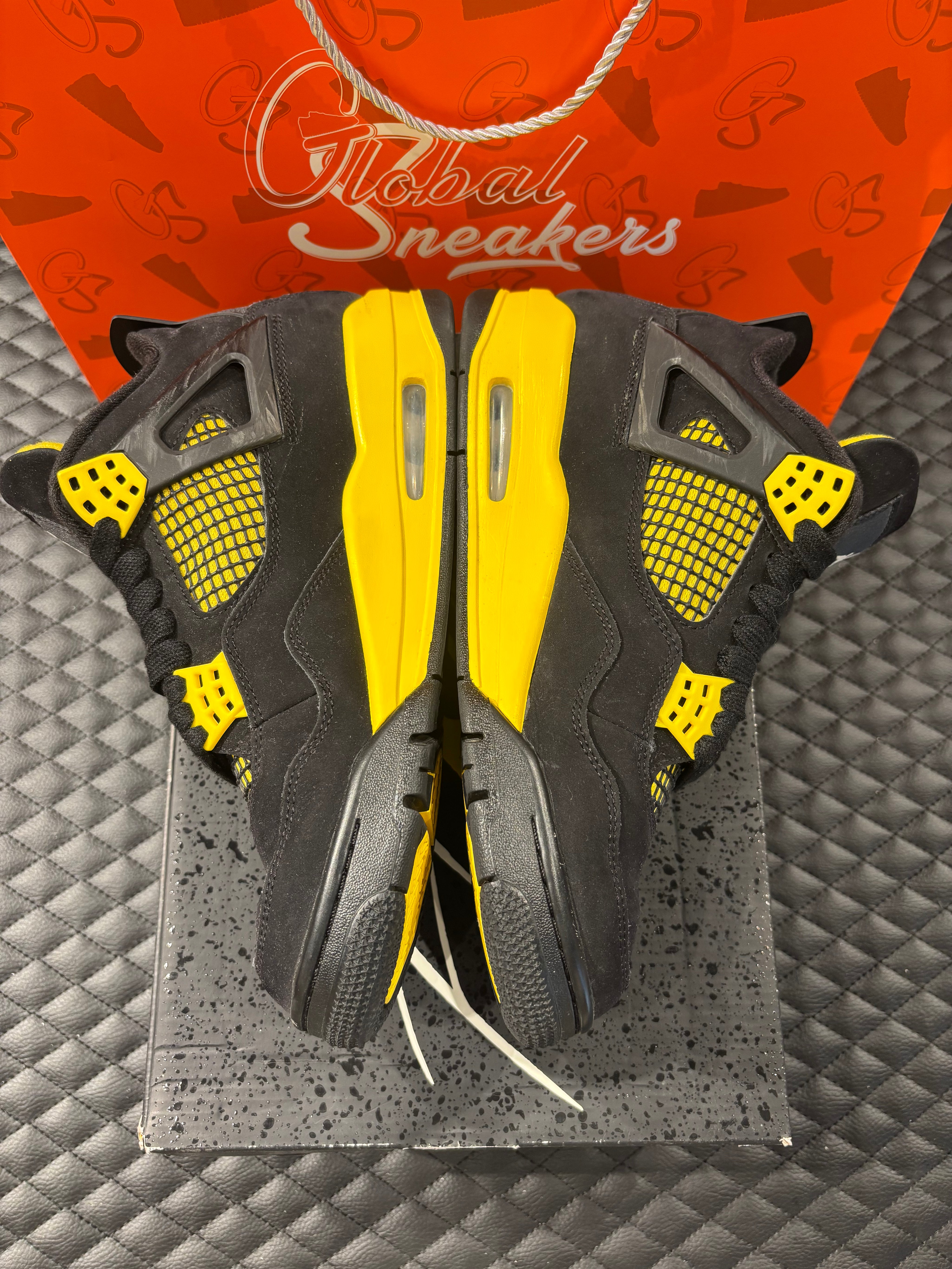 Jordan 4 Rétro Thunder d’occasion en état 8,5/10, suede noir, détails jaunes, sneaker sans boîte.
