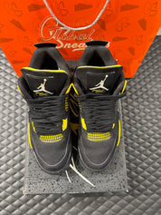 Jordan 4 Rétro Thunder d’occasion en état 8,5/10, suede noir, détails jaunes, sneaker sans boîte.
