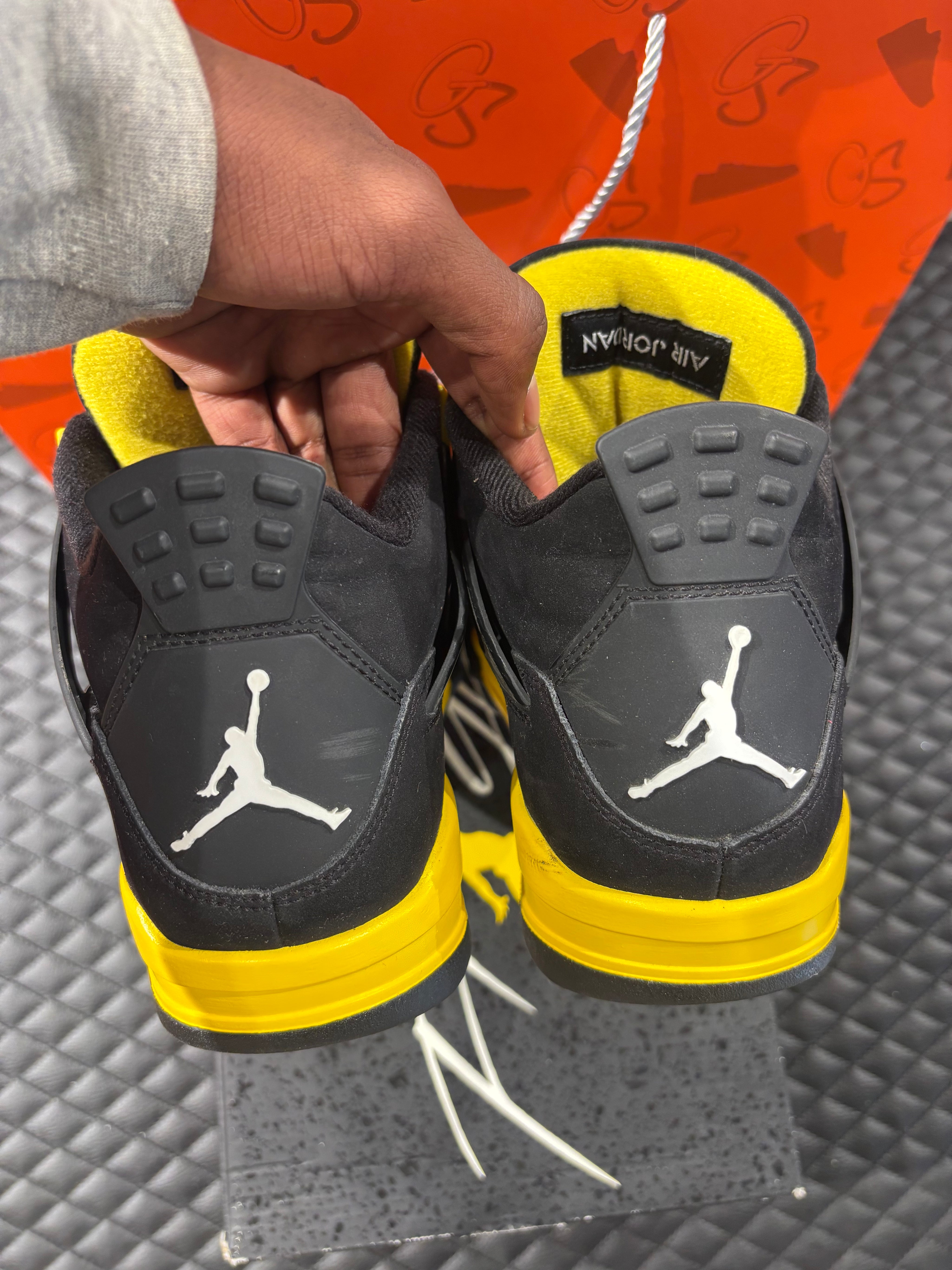 Jordan 4 Rétro Thunder d’occasion en état 8,5/10, suede noir, détails jaunes, sneaker sans boîte.
